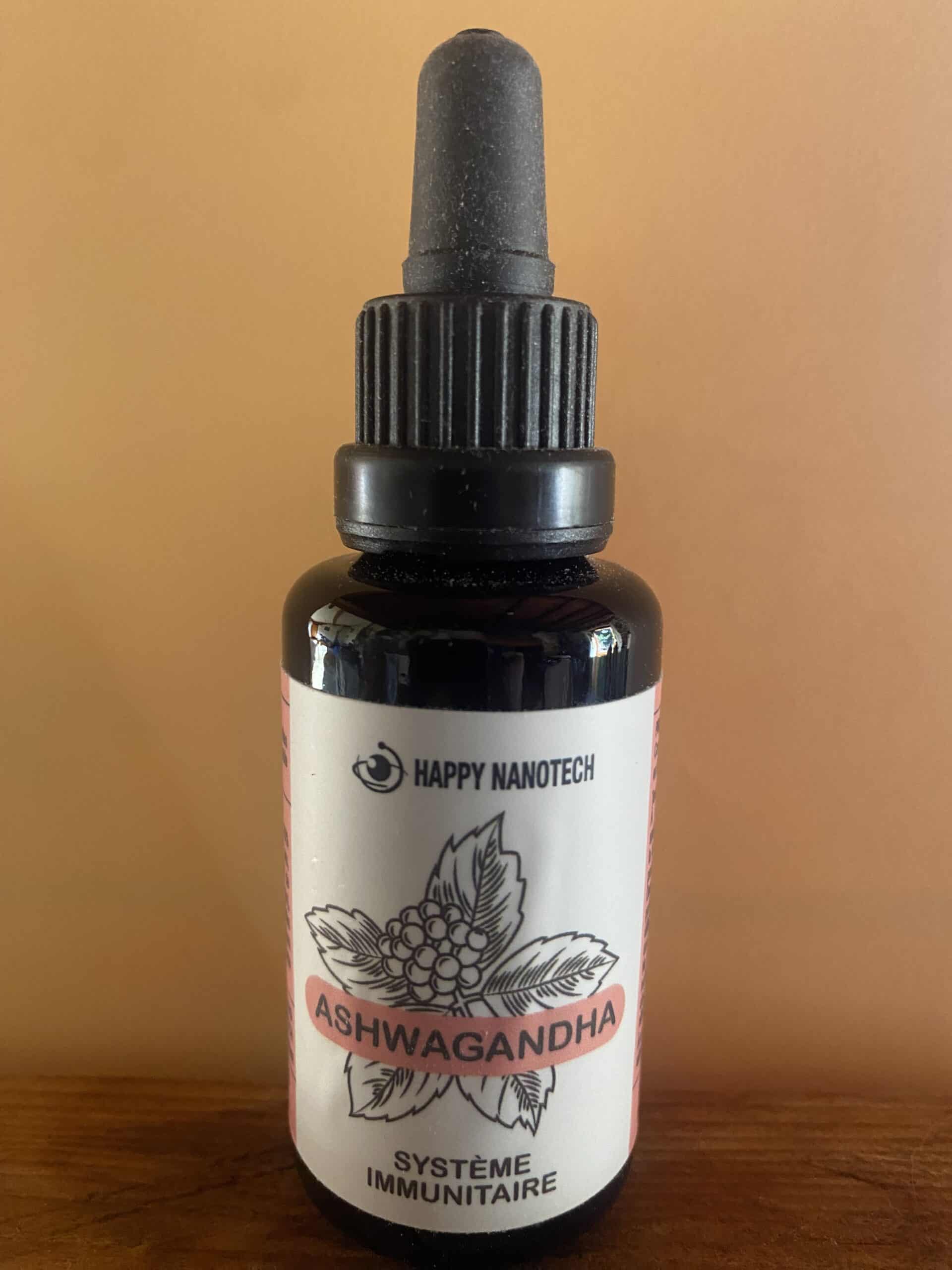 Flacon compte-gouttes Happy Nanotech d'Ashwagandha pour le système immunitaire. Étiquette blanche, texte rose et noir, sur fond orange uni.