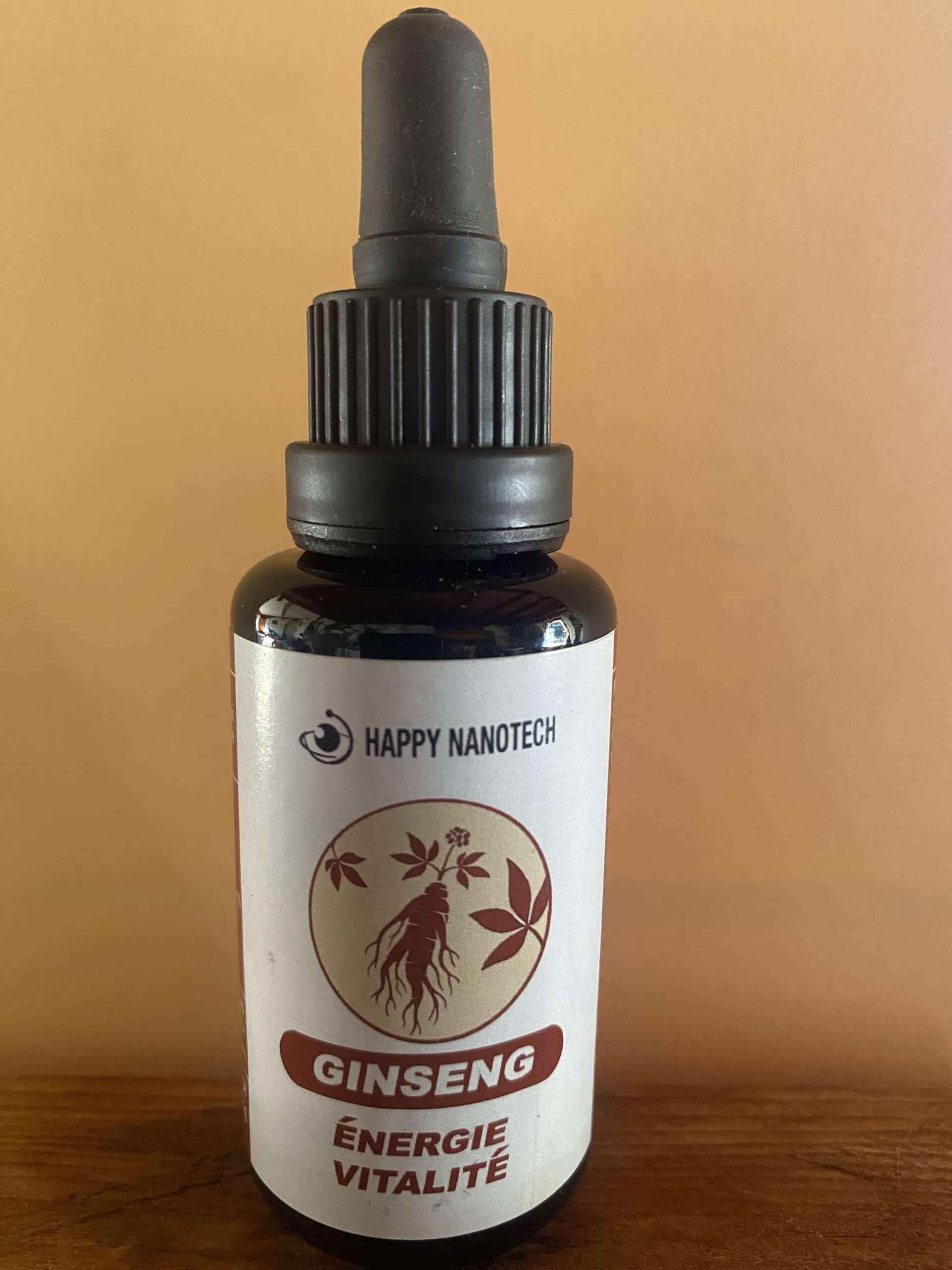 Flacon compte-gouttes Happy Nanotech Ginseng, étiquette avec racine et texte "ÉNERGIE VITALITÉ", sur fond orange et bois.
